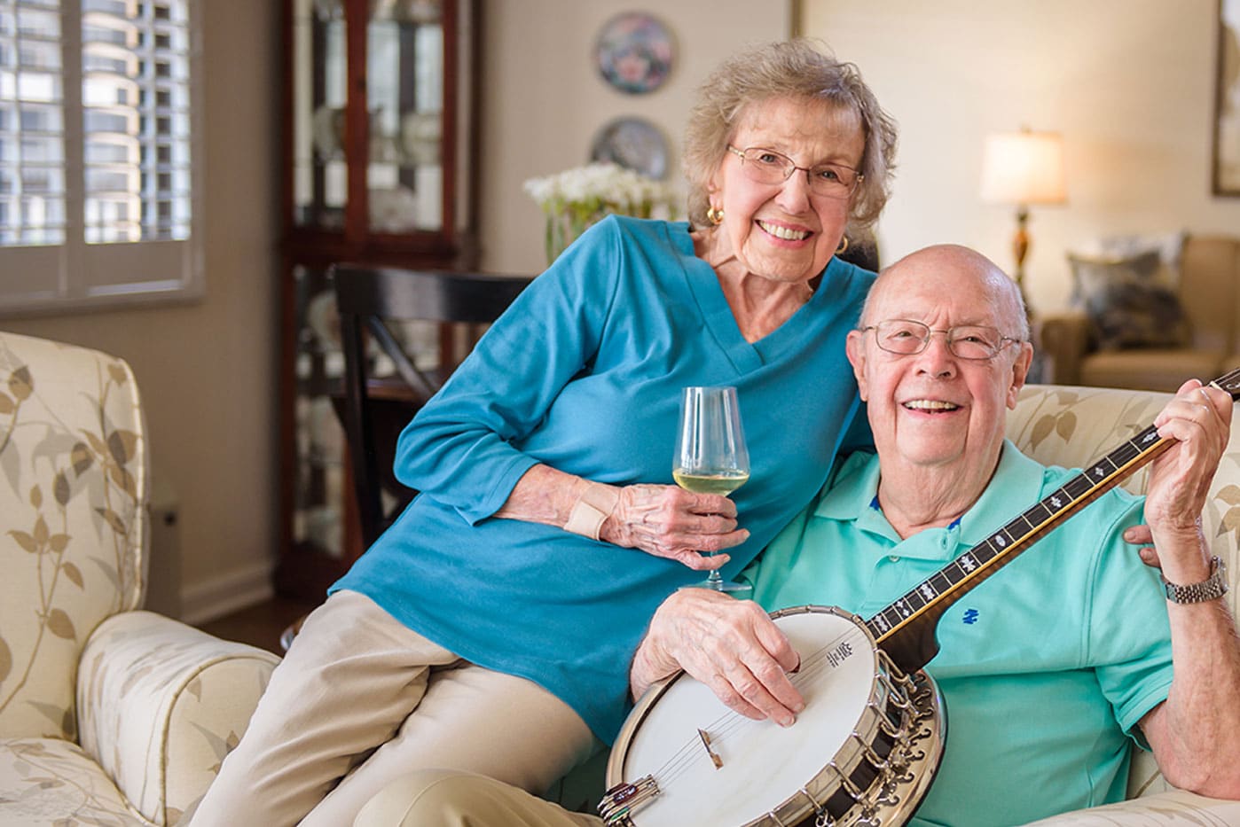 Senior woman sitting on mans lap with banjo