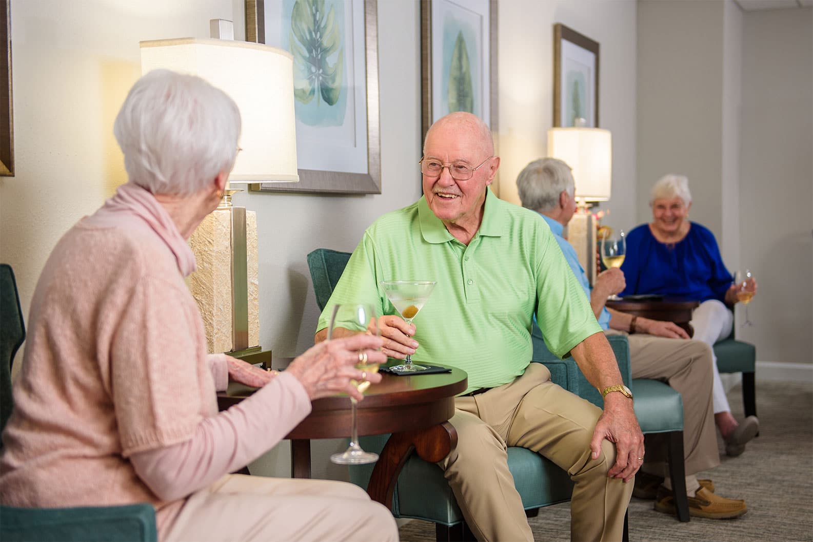 Senior man smiling with martini glass with senior woman
