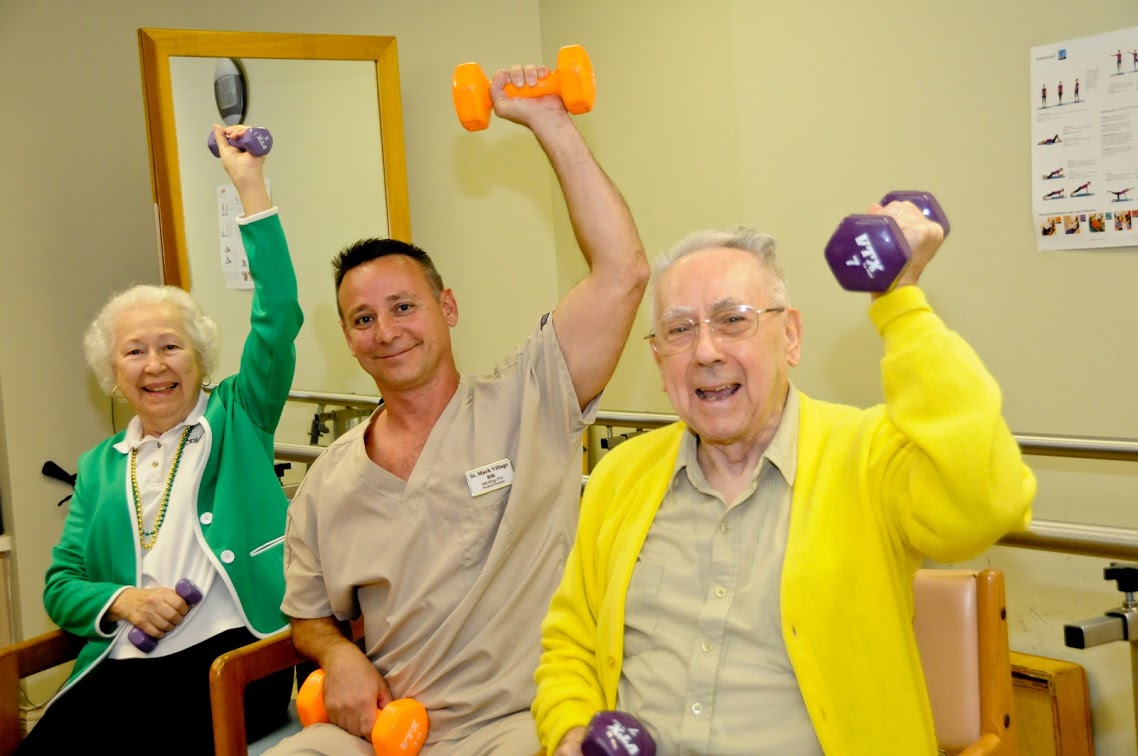 A group of elderly people lifting dumbbells in a gym.