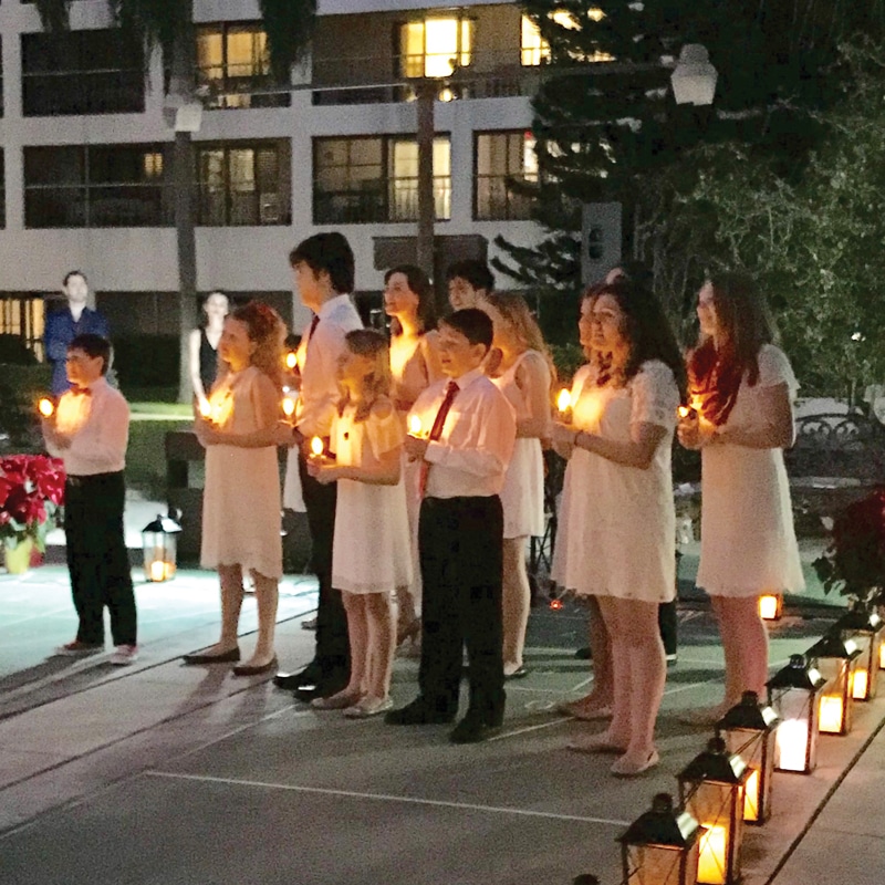 A group of people holding candles in front of a building.
