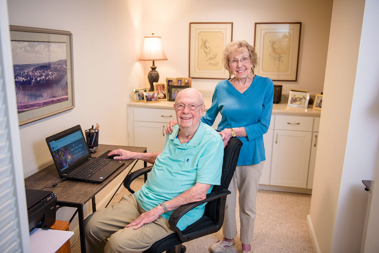 Senior couple at computer smiling at camera