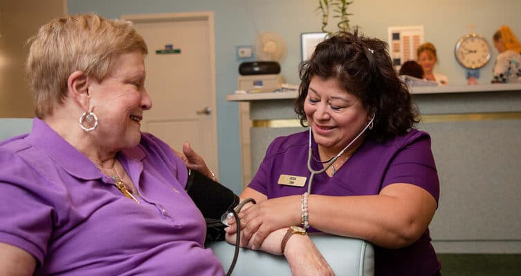 A nurse checks a patient's blood pressure.