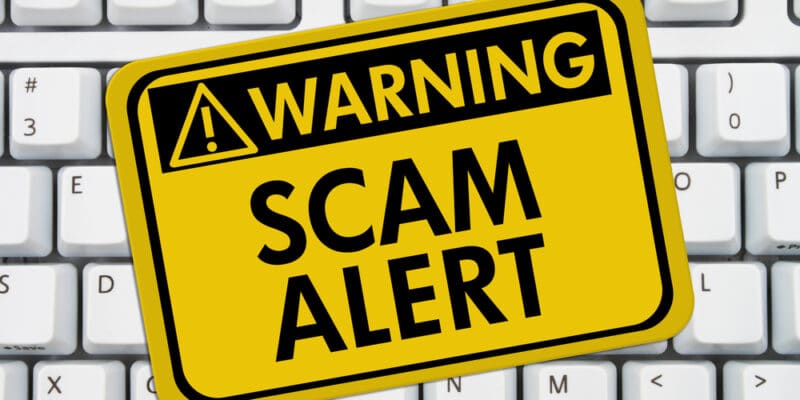 Warning scam alert against seniors on a computer keyboard.