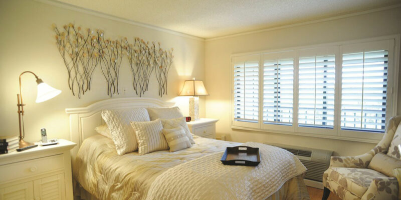 A bed with a white comforter and pillows.