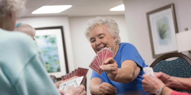 A group of elderly women playing cards at a table.