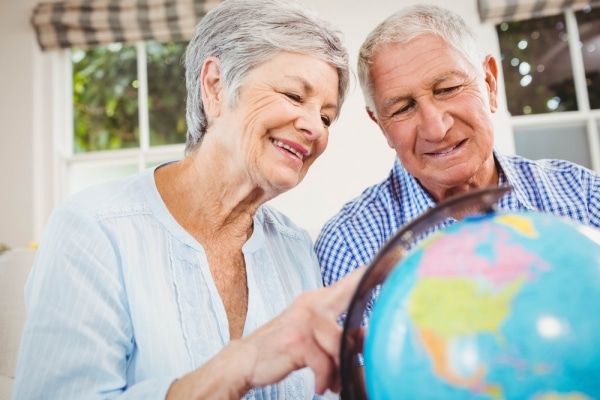 An older couple looking at a globe.