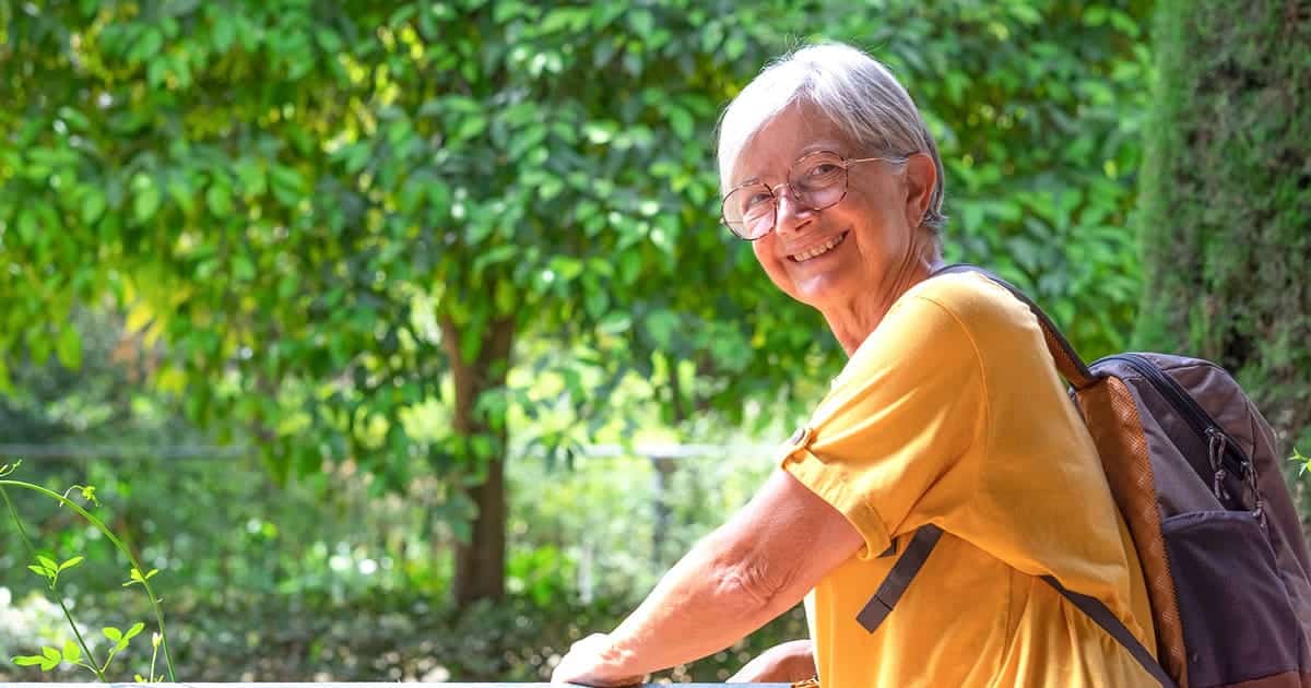 An older woman sitting on a bench at Palm Harbor Parks.