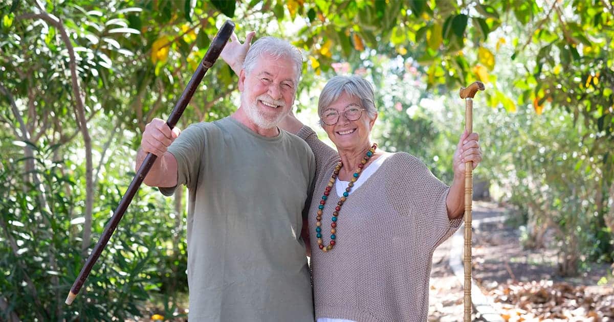         Description: An older couple reaping the benefits of getting outdoors in a forest.
        
        Keywords: Benefits, outdoors