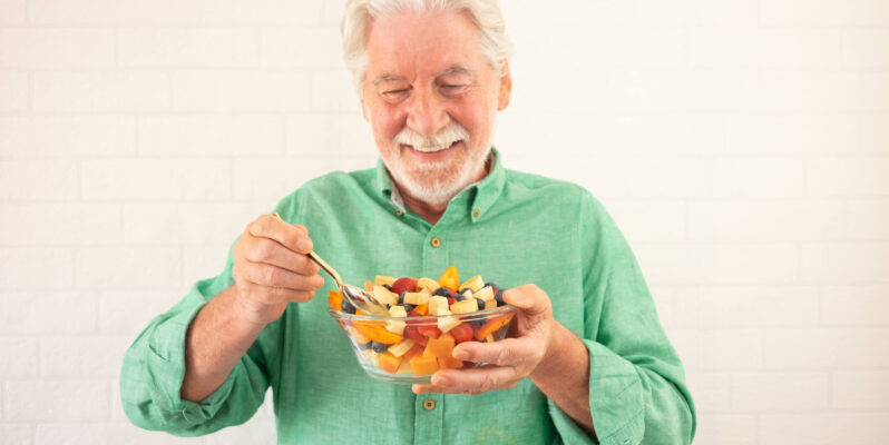 Why Good Nutrition Is So Important for Older Adults, and What It Might Mean When They Overlook Their Own Diet Smiling senior bearded man holding bowl of fresh seasonal fruit ready to eat. Breakfast or lunch, eat healthy and dietary