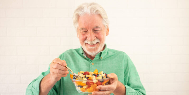 Why Good Nutrition Is So Important for Older Adults, and What It Might Mean When They Overlook Their Own Diet Smiling senior bearded man holding bowl of fresh seasonal fruit ready to eat. Breakfast or lunch, eat healthy and dietary