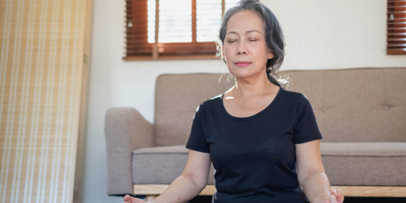 Meditation can relieve anxiety, pain, and depression, and all without the side effects of a medication. Here’s a beginner’s guide for seniors. Woman sitting with legs crossed meditating