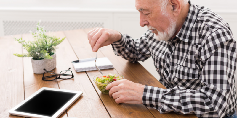 Older adult man at dinner table with loss of appetite