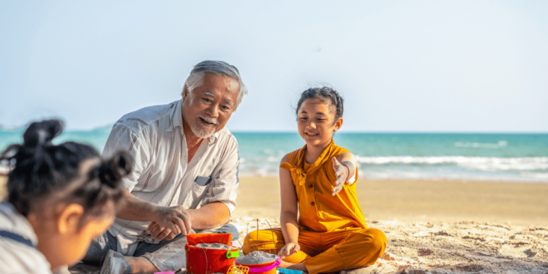 Senior man on beach traveling with grandkids