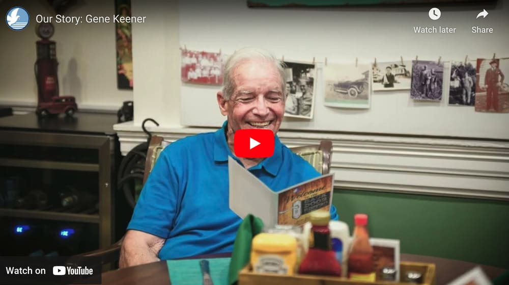 A man sitting at a table, radiating a smile that embodies a promise of life care.