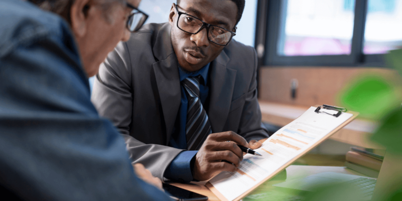 Senior man meeting with financial advisor on how to fund senior living expenses.